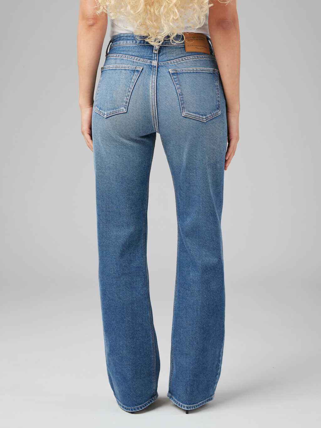 Blonde curly-haired model wearing Classic Comfort Bootcut Jeans