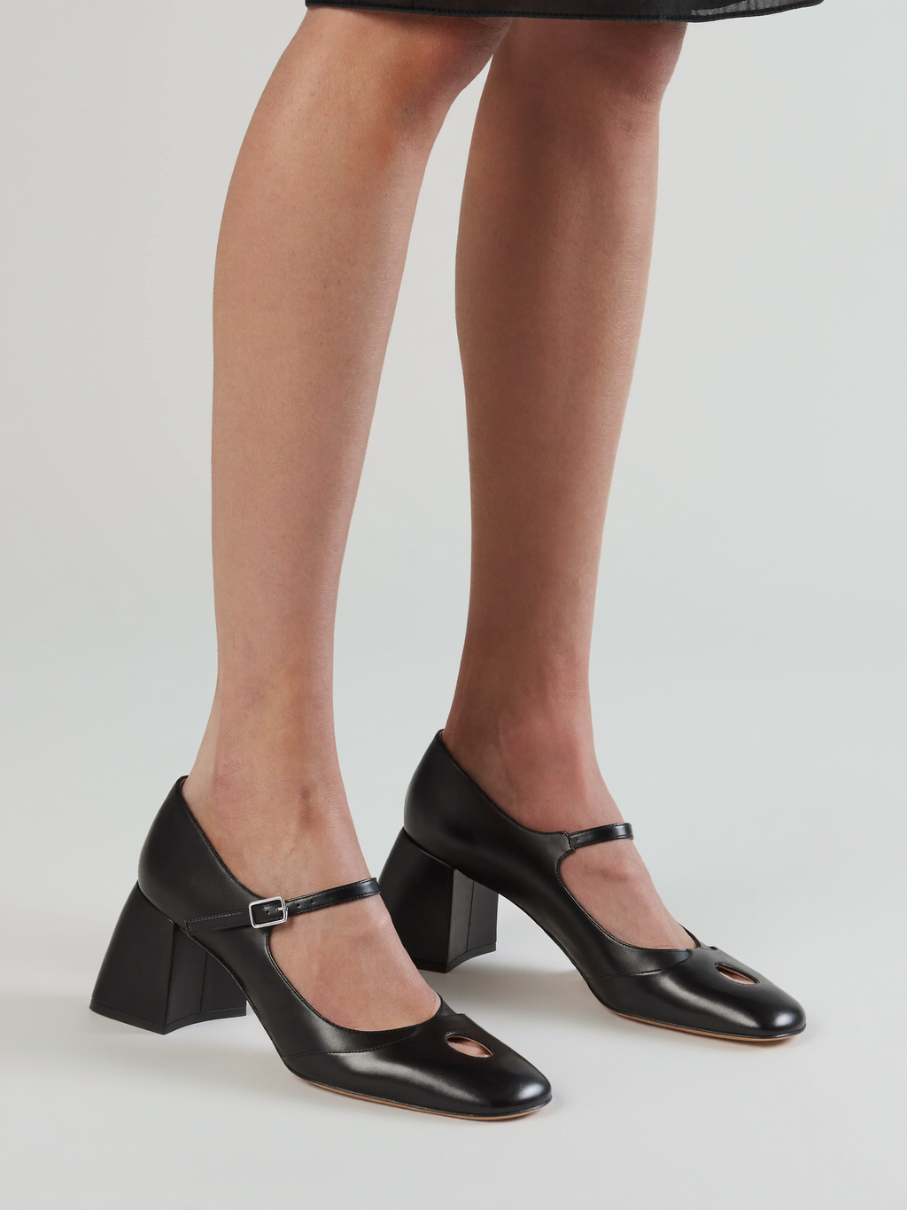 Model wearing black Mary Jane block heel pumps