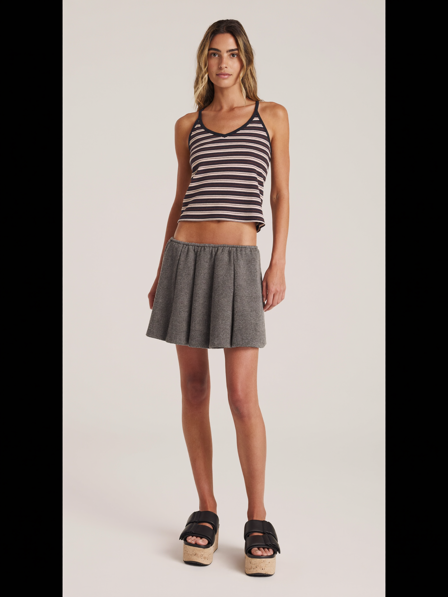 Full body model wearing black braided strap slide sandals